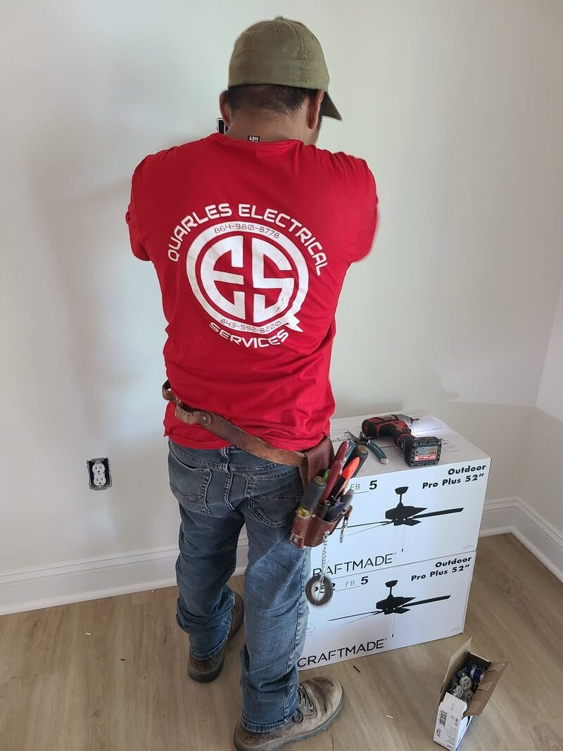 Quarles Electrical Services technician in branded shirt installing ceiling fans